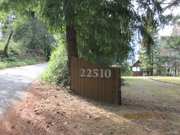 a sign that is sitting in front of a tree