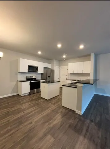 a view of kitchen with granite countertop stainless steel appliances