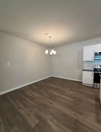 an empty room with wooden floor painted walls and windows