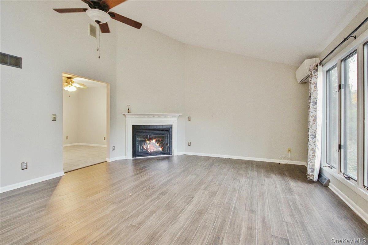 102 Old Post Road Marlboro, NY 12542 - Photo 11 of 46 an empty room with wooden floor fireplace and windows