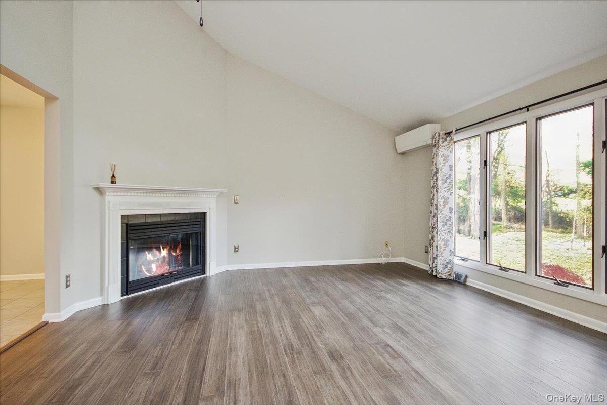 102 Old Post Road Marlboro, NY 12542 - Photo 13 of 46 an empty room with wooden floor fireplace and windows