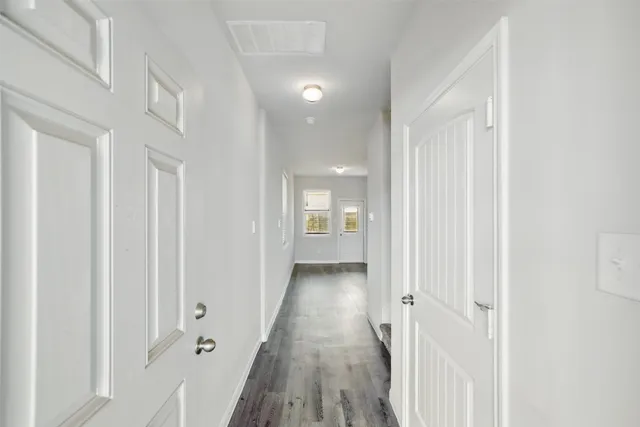 a view of a hallway with wooden floor