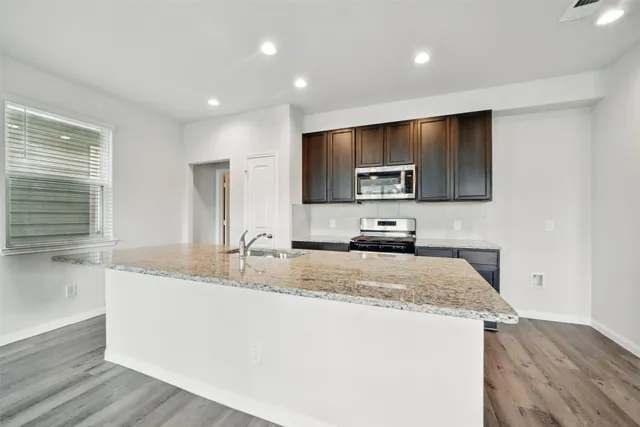 a kitchen with a sink a counter top space cabinets and appliances