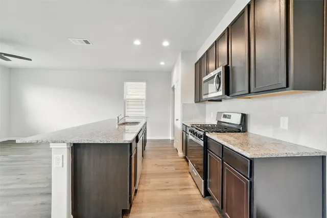 a kitchen with stainless steel appliances granite countertop a sink stove and refrigerator