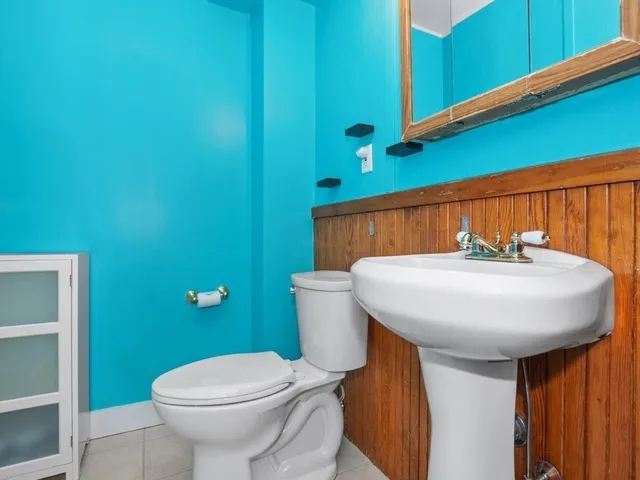 a bathroom with a sink a toilet and a mirror