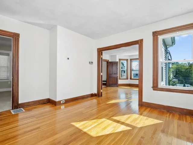a view of a room with wooden floor and painting on the wall