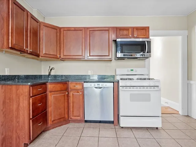 a kitchen with stainless steel appliances granite countertop a stove microwave and cabinets