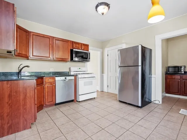 a kitchen with a refrigerator sink and cabinets