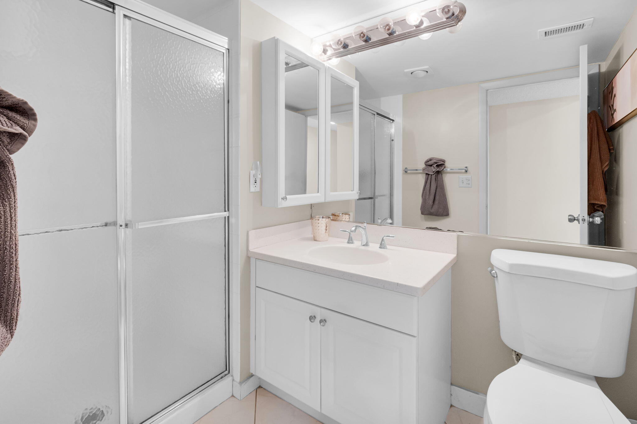 12 Westgate Lane, Unit C Boynton Beach, FL 33436 - Photo 28 of 54 a bathroom with a toilet sink and mirror