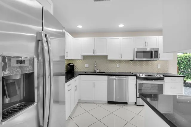 a kitchen with stainless steel appliances granite countertop a refrigerator and a stove top oven