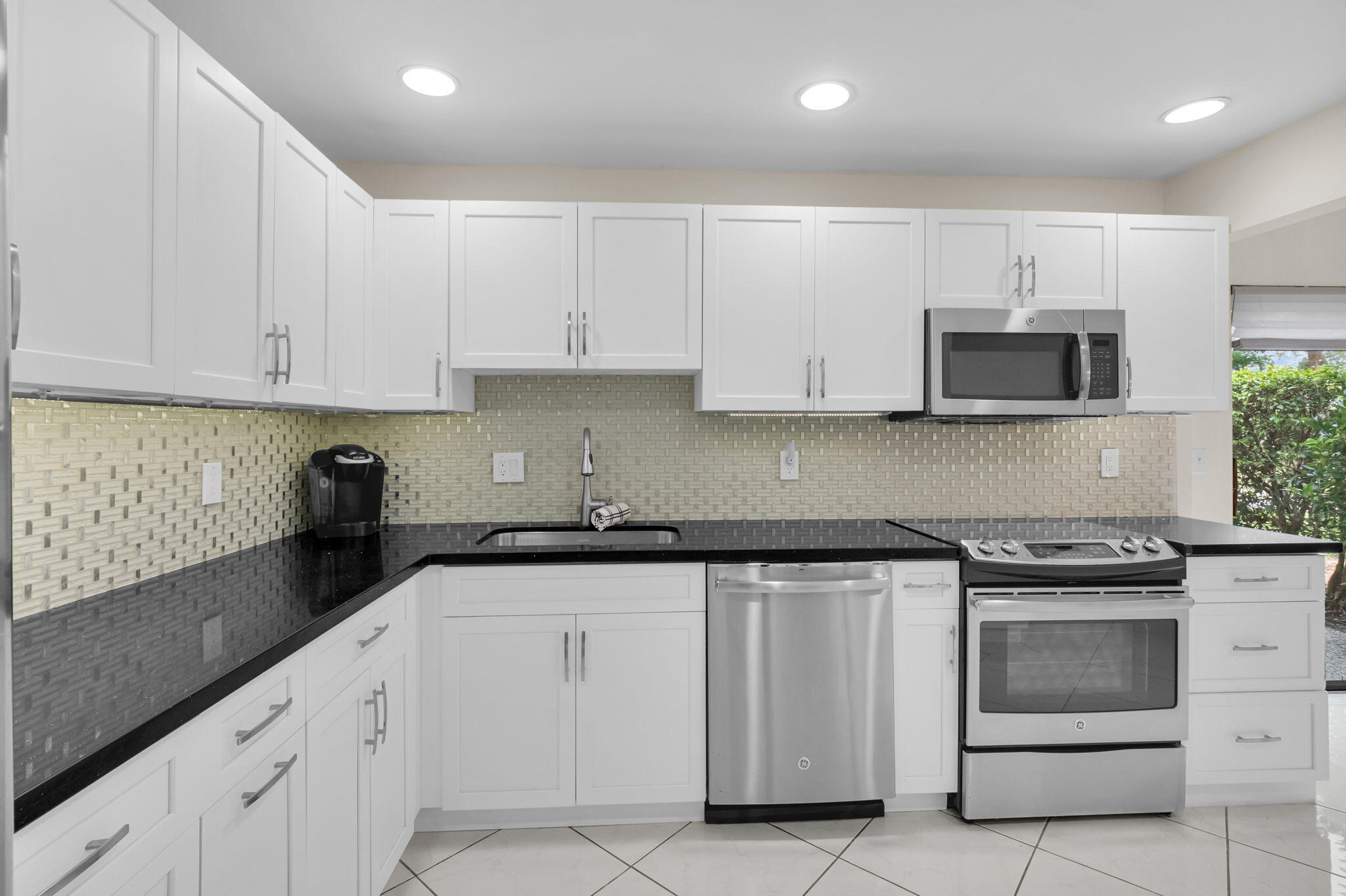 12 Westgate Lane, Unit C Boynton Beach, FL 33436 - Photo 6 of 54 a kitchen with granite countertop white cabinets and stainless steel appliances