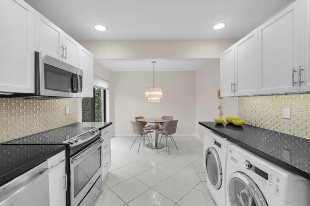 a kitchen with granite countertop a sink a stove and cabinets