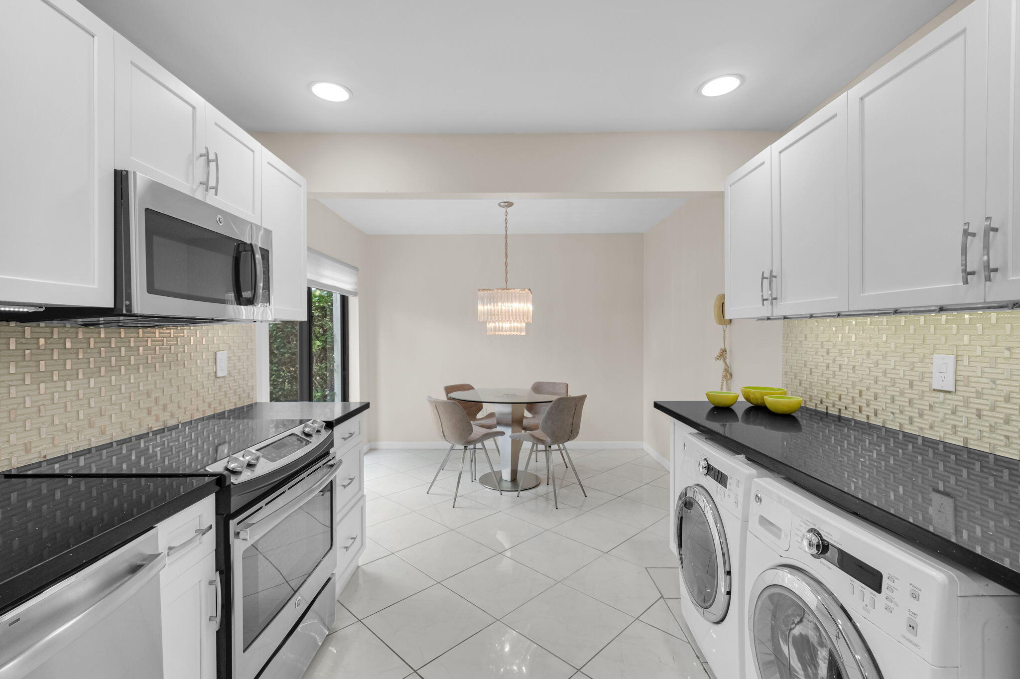 12 Westgate Lane, Unit C Boynton Beach, FL 33436 - Photo 7 of 54 a kitchen with granite countertop a sink a stove and cabinets