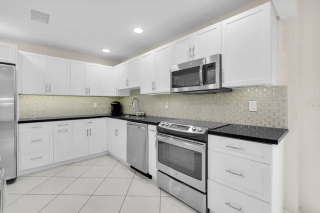 a kitchen with cabinets stainless steel appliances and a sink