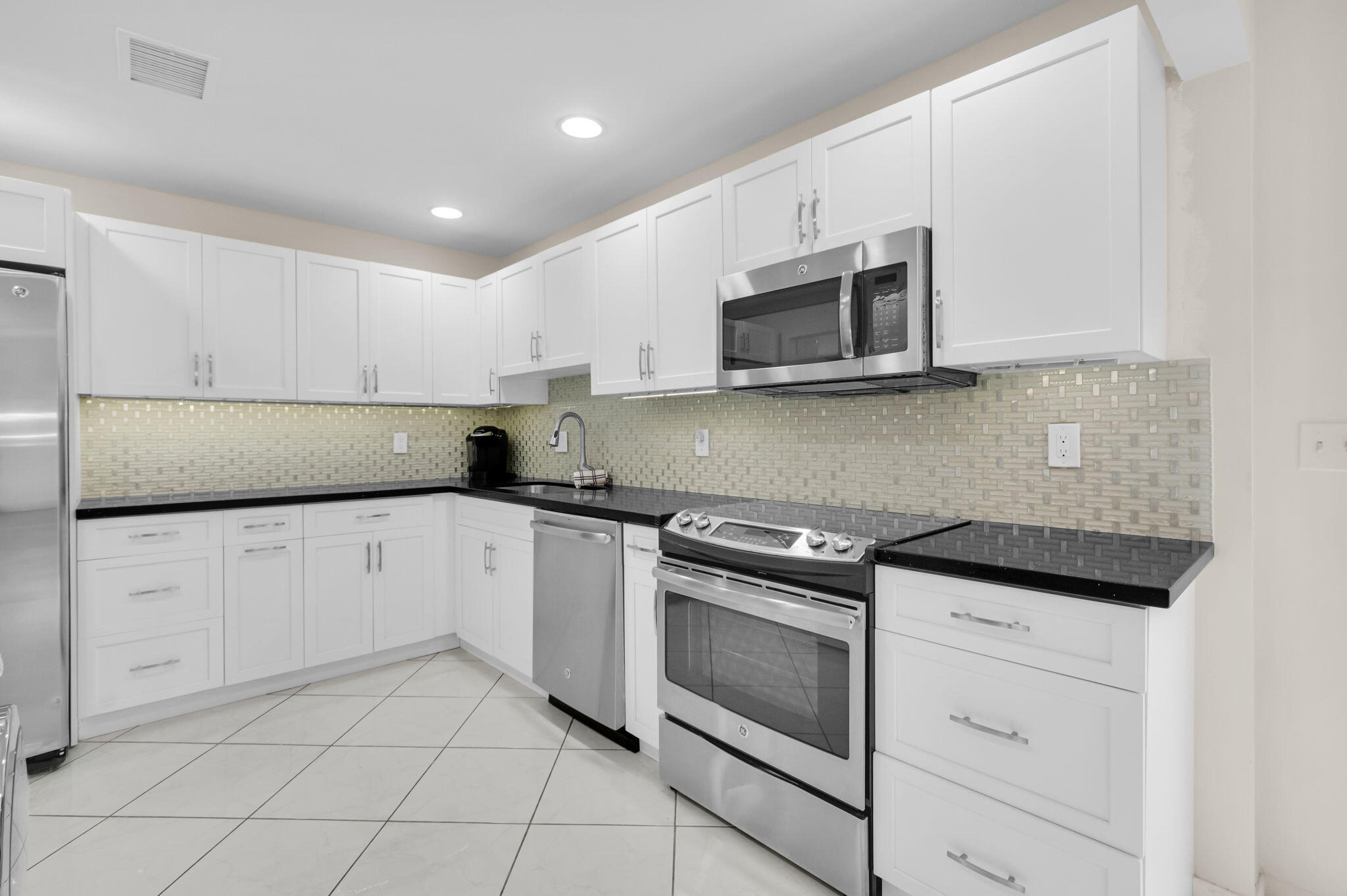 12 Westgate Lane, Unit C Boynton Beach, FL 33436 - Photo 10 of 54 a kitchen with cabinets stainless steel appliances and a sink