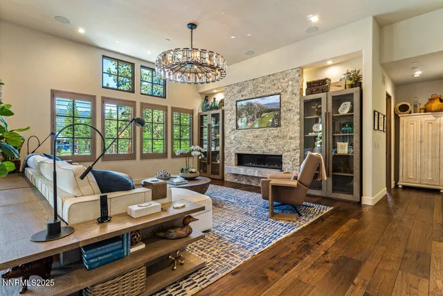 a living room with furniture a chandelier and a fireplace