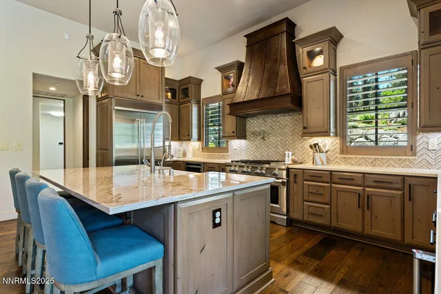 a kitchen with cabinets a sink stainless steel appliances and dining table