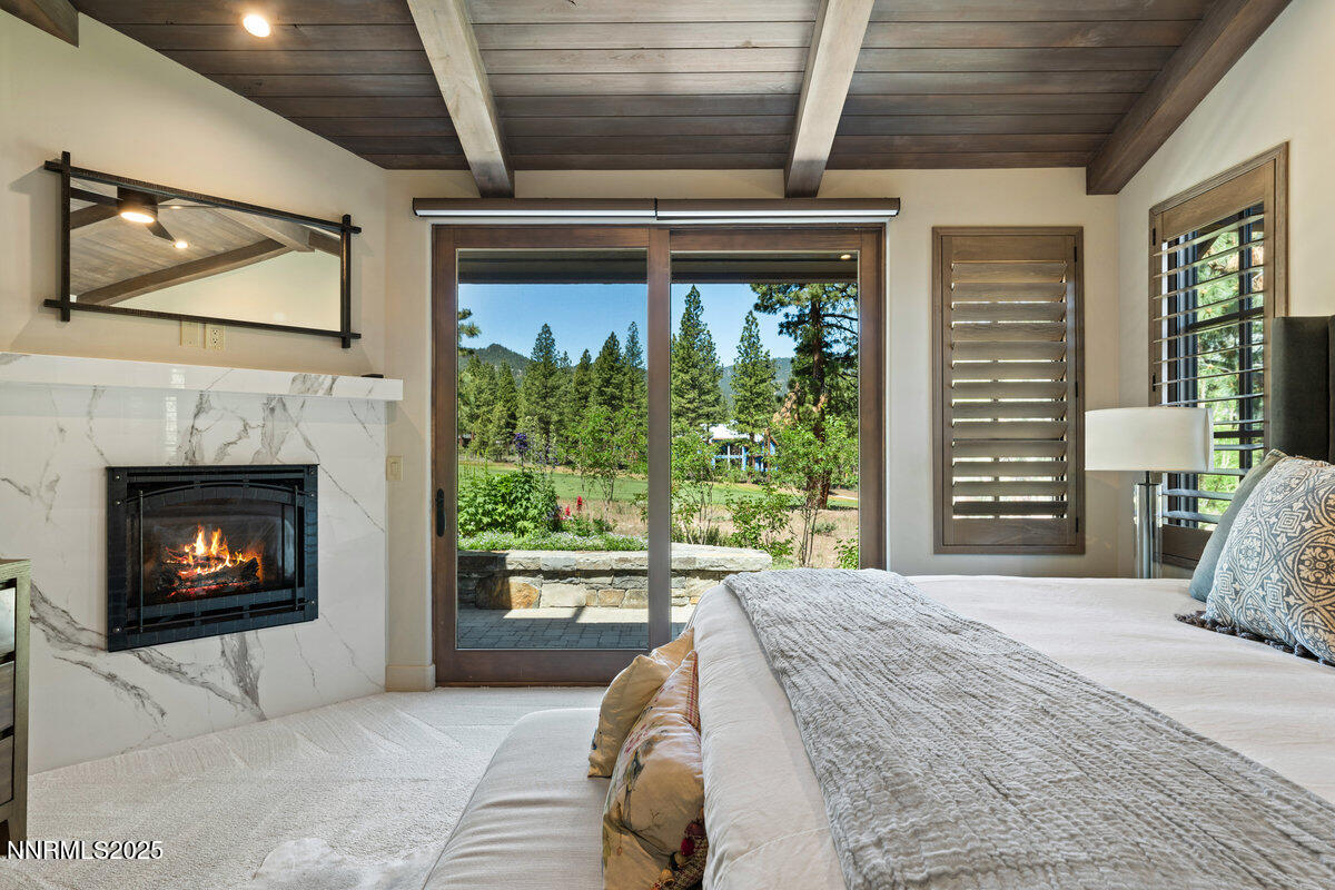 253 Mill Race Loop Carson City, NV 89705 - Photo 10 of 44 a bedroom with a bed a fireplace and a large window