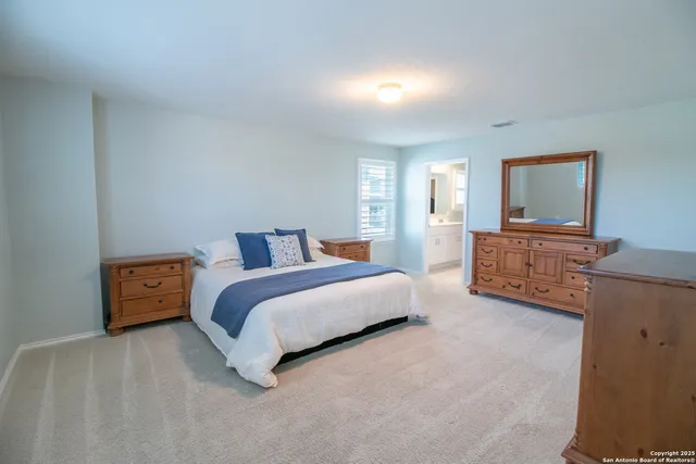 a spacious bedroom with a bed and a dresser in it