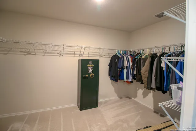 a view of walk in closet with clothes and shoes
