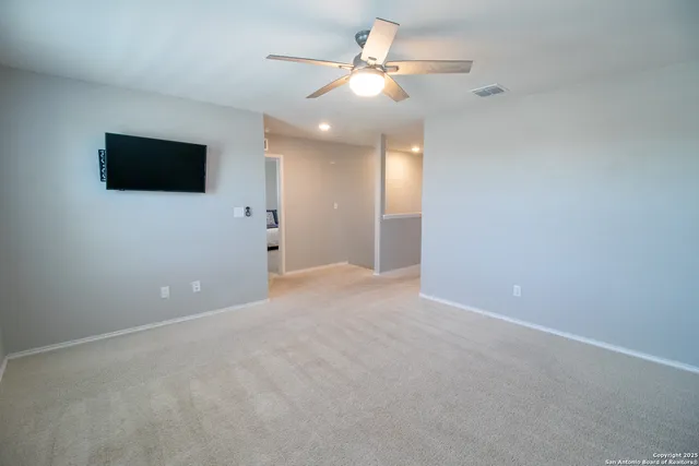 a view of an empty room with a ceiling fan