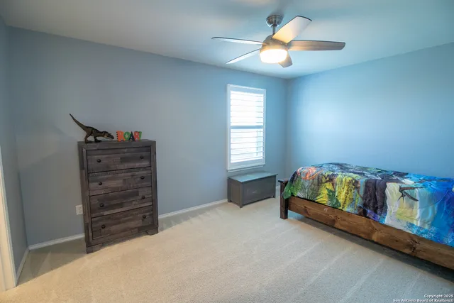 a bedroom with a bed and a chandelier fan