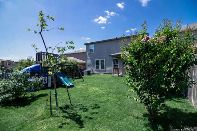 a view of a house with a yard and potted plants