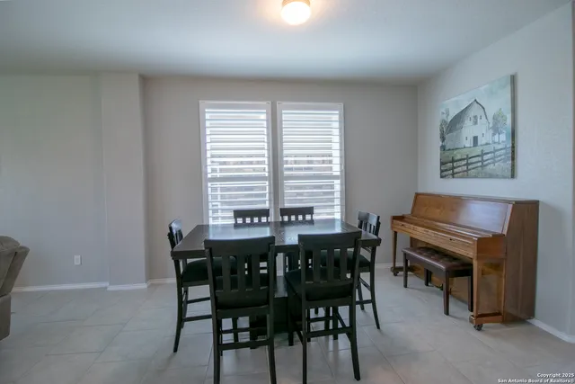 a dining room with a wooden table and chairs