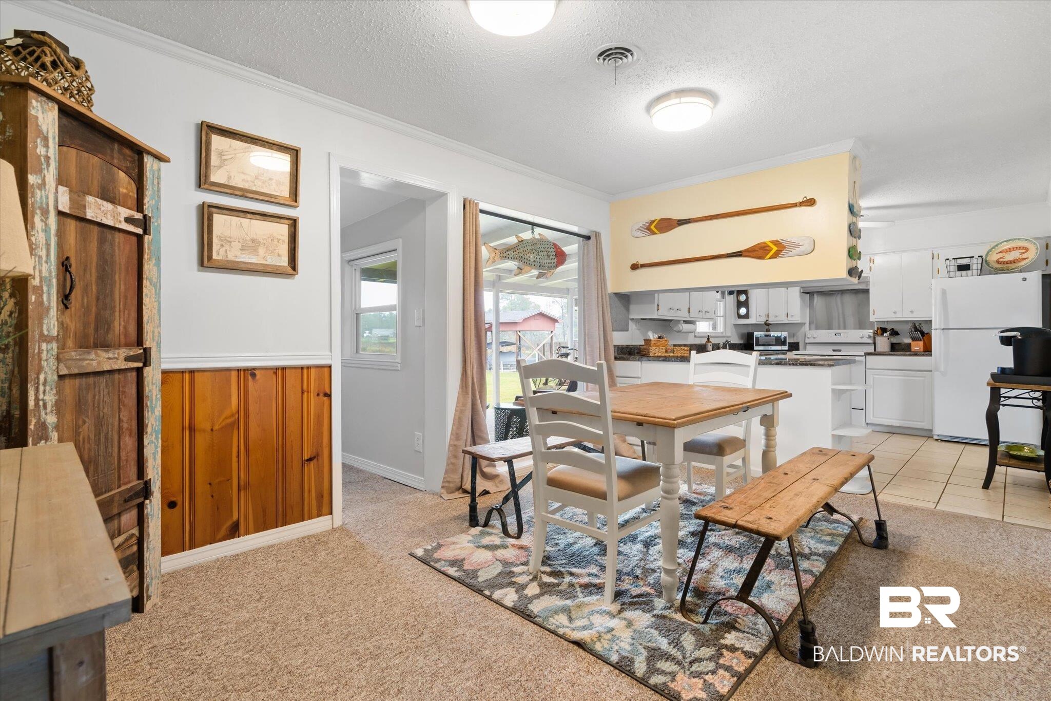4570 Benson Road Mobile, AL 36619 - Photo 7 of 34 Dining room with wood walls, a textured ceiling, light colored carpet, and ornamental molding