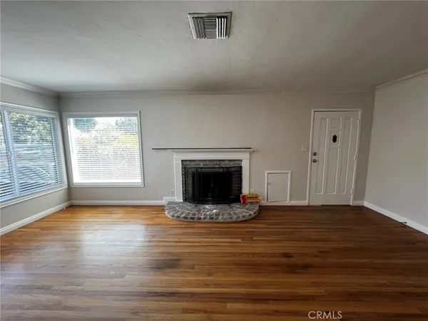 a view of an empty room with glass door and wooden floor