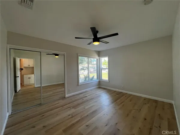 a view of wooden floor and a chandelier fan in a room