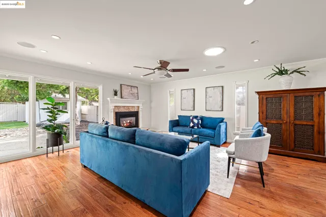 a living room with a fireplace a rug and a floor to ceiling window
