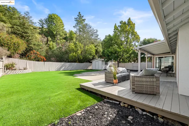 a view of backyard with tub and trees in the background
