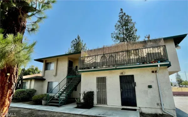 a front view of a house with a tree