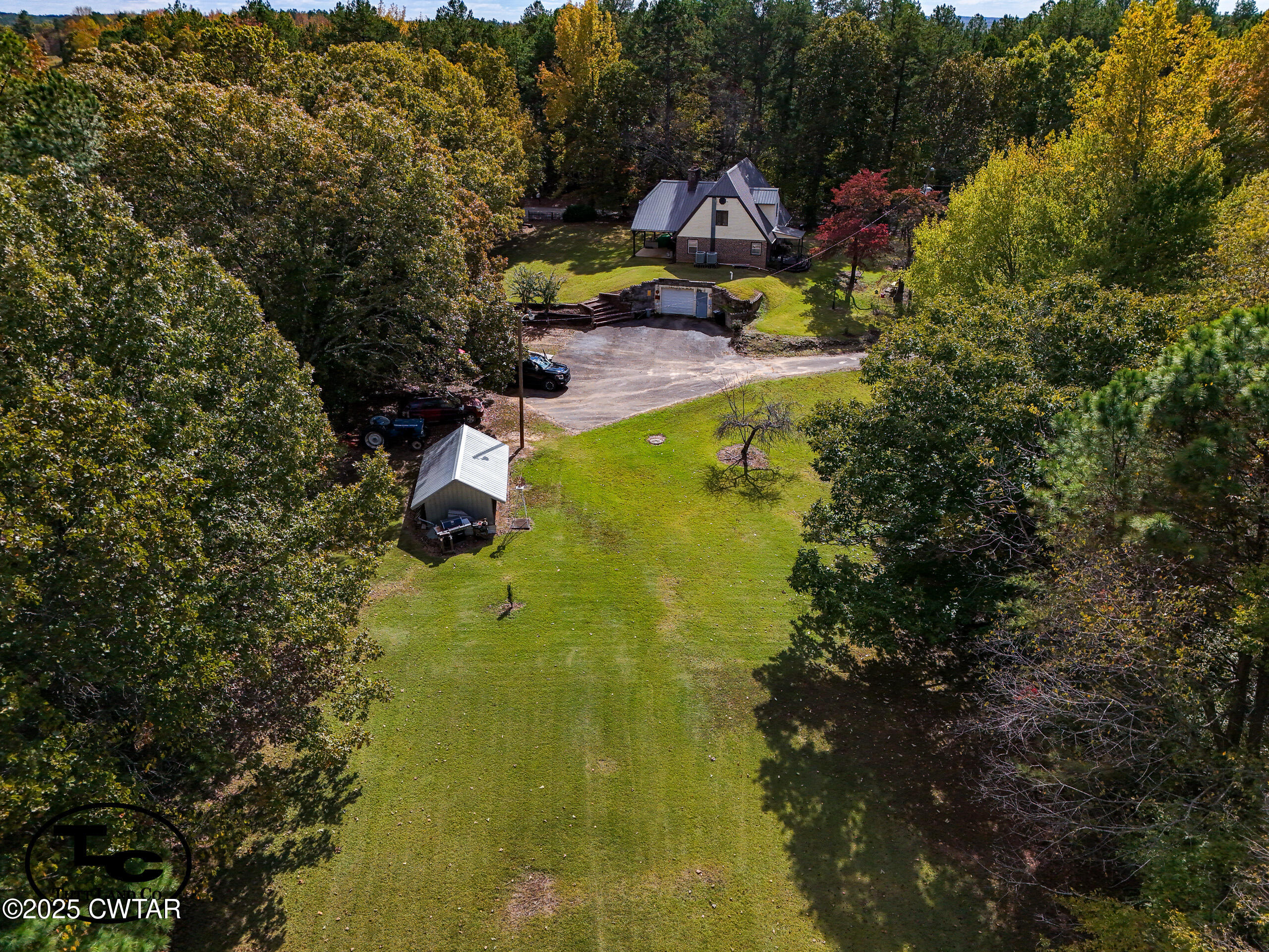 a view of swimming pool of water with lawn chairs and large trees