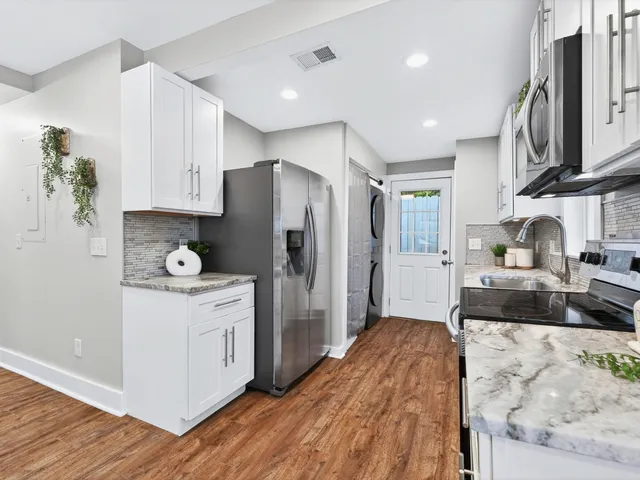 a kitchen with stainless steel appliances granite countertop a refrigerator sink and stove