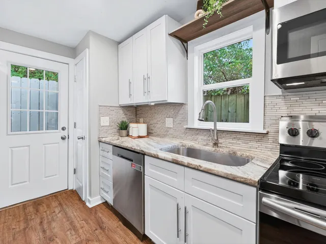 a kitchen with stainless steel appliances granite countertop a sink stove and cabinets