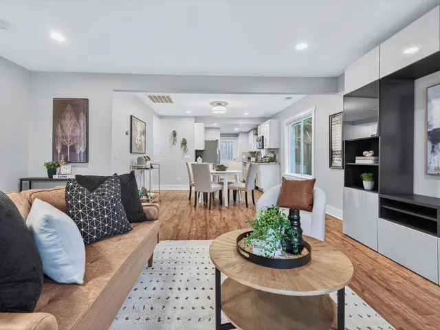 a living room with furniture and a dining table with kitchen view