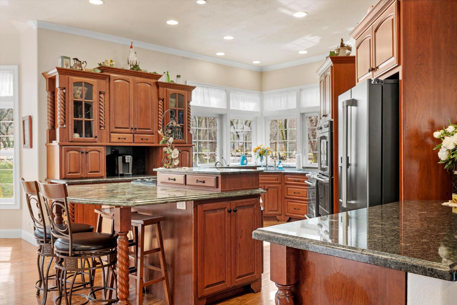 2661 Oak Ln Drive Rescue, CA 95672 - Photo 19 of 69 a kitchen with kitchen island granite countertop a table chairs microwave and refrigerator