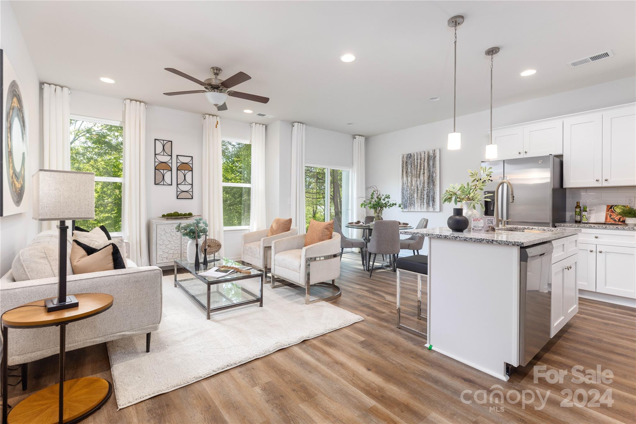 a living room with kitchen island furniture and a chandelier