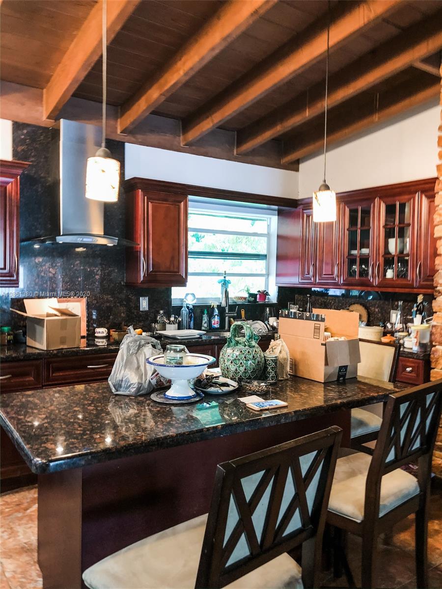 70 Samana Drive Miami, FL 33133 - Photo 8 of 10 a kitchen with a table chairs stove and cabinets