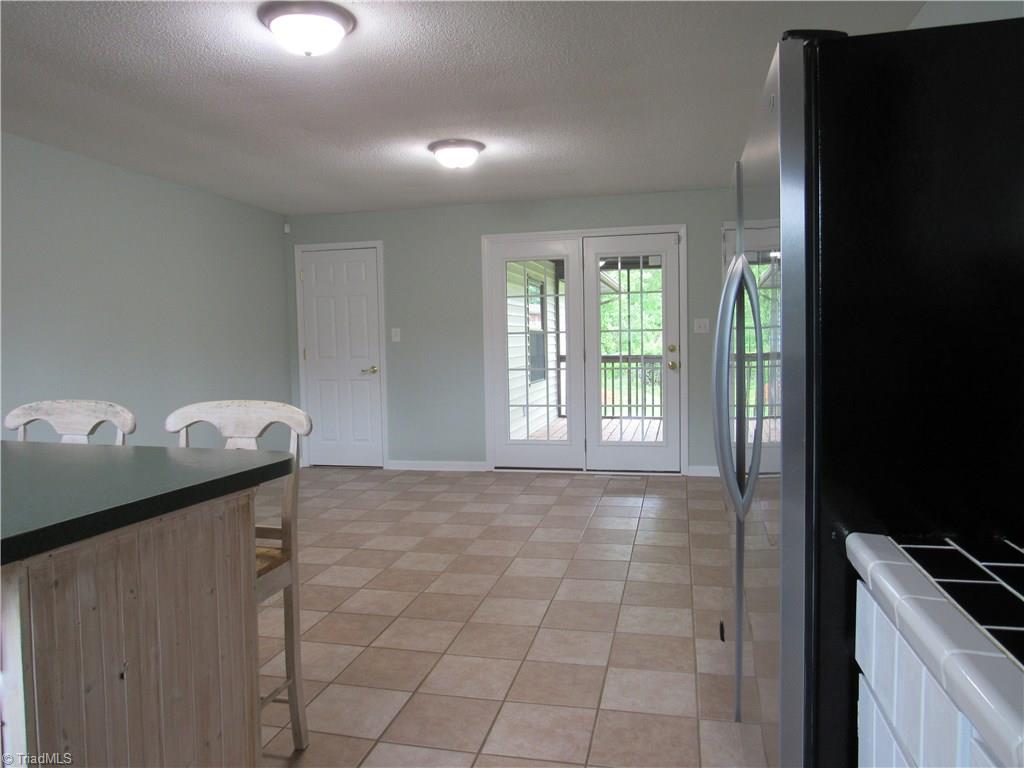 306 Summit Road High Point, NC 27265 - Photo 8 of 27 Tile flooring extends into the dining area. French doors exit to covered deck. A nice large pantry is located behind the interior door on the left.