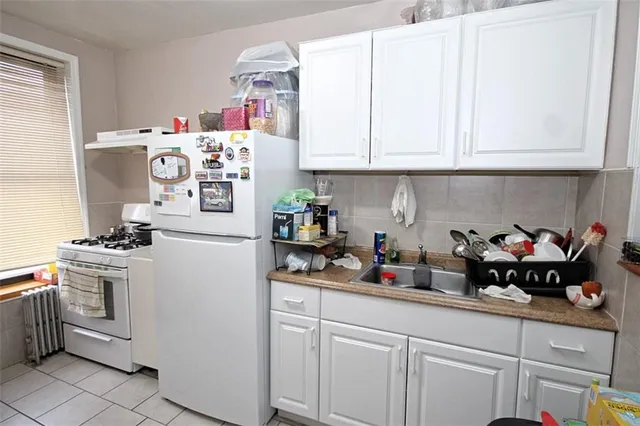a kitchen with white cabinets and white appliances