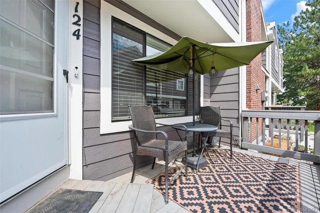 a view of a patio with table and chairs under an umbrella