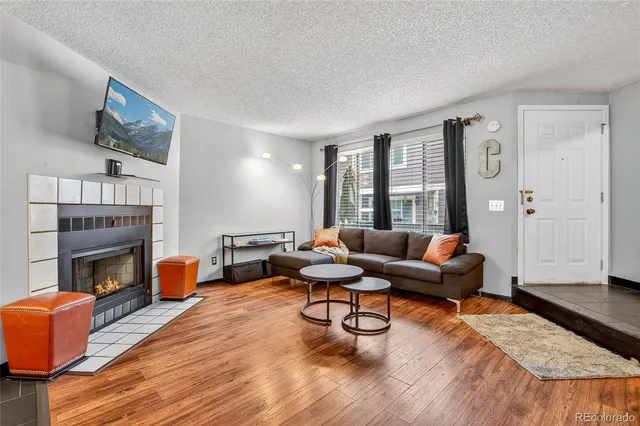 a living room with fireplace furniture and a wooden floor