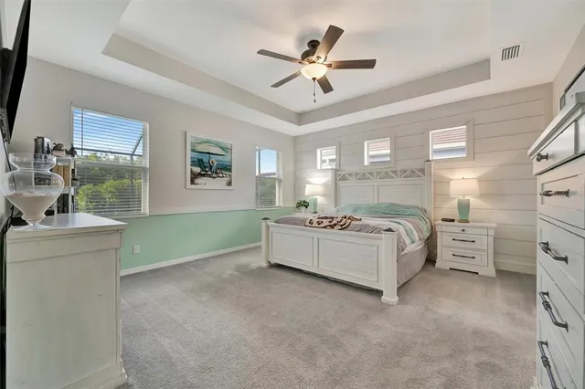 a bed room with a bed and a ceiling fan