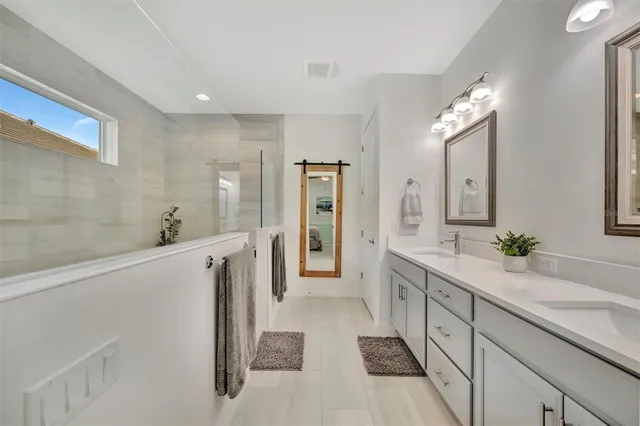 a bathroom with a tub sink and mirror