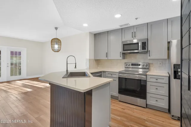 a kitchen with stainless steel appliances granite countertop a stove and a refrigerator