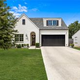 a front view of a house with a garden and yard