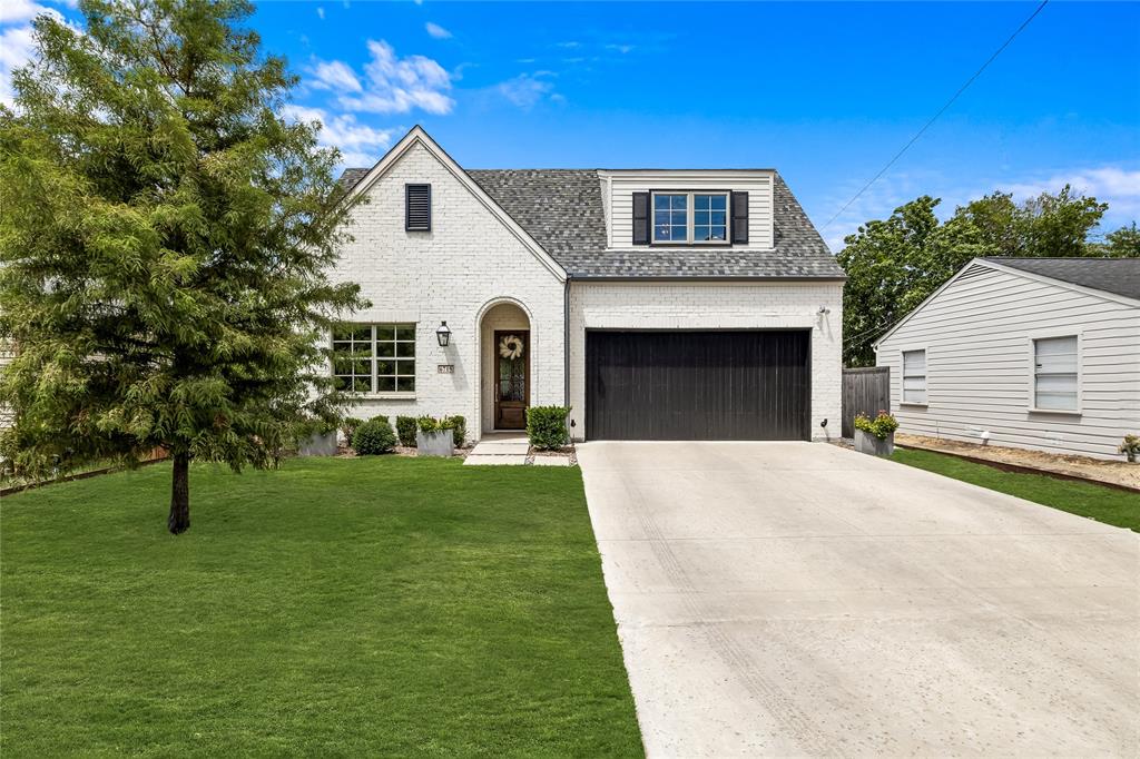 a front view of a house with a garden and yard